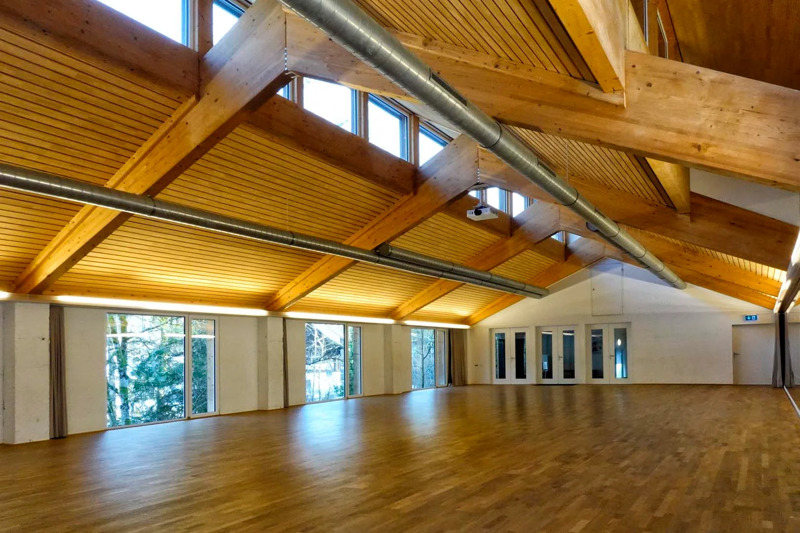 Flow60 dance hall — spacious wooden room with high ceilings, clerestory windows, and warm hardwood floors